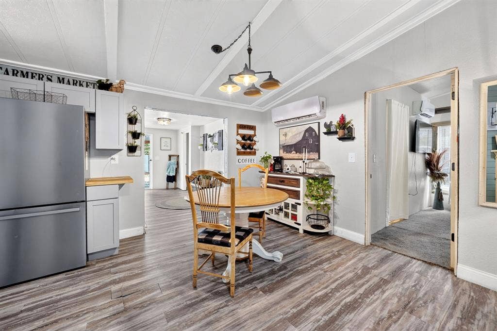 302 Longleaf Street, Gun Barrel City, TX 75156 Vaulted ceiling with exposed beams, wood-finish flooring, light gray cabinetry, stainless steel refrigerator, and a suspended light fixture