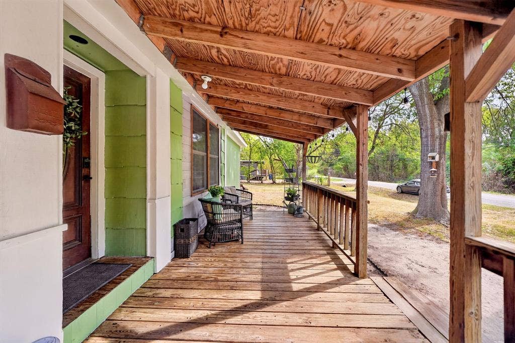 302 Longleaf Street, Gun Barrel City, TX 75156 Expansive wooden porch with exposed beam ceiling, wood-finish flooring, and a detailed wooden front door