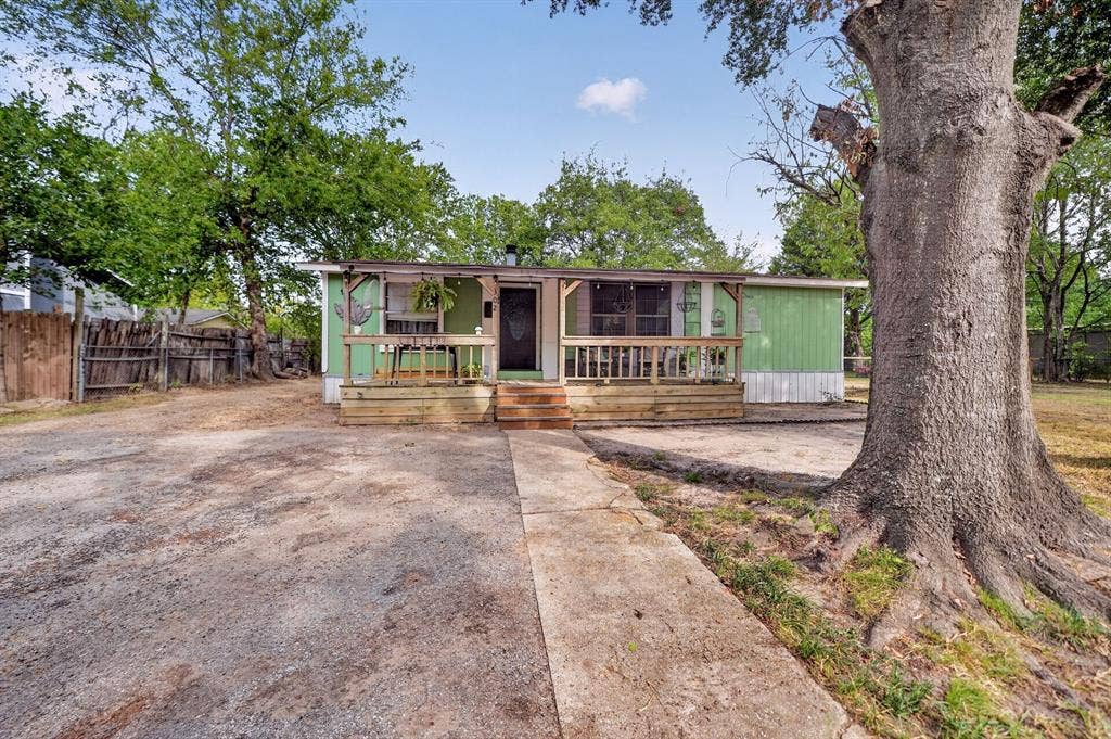302 Longleaf Street, Gun Barrel City, TX 75156 Expansive gravel driveway, wood fencing, and a front porch with wood railing