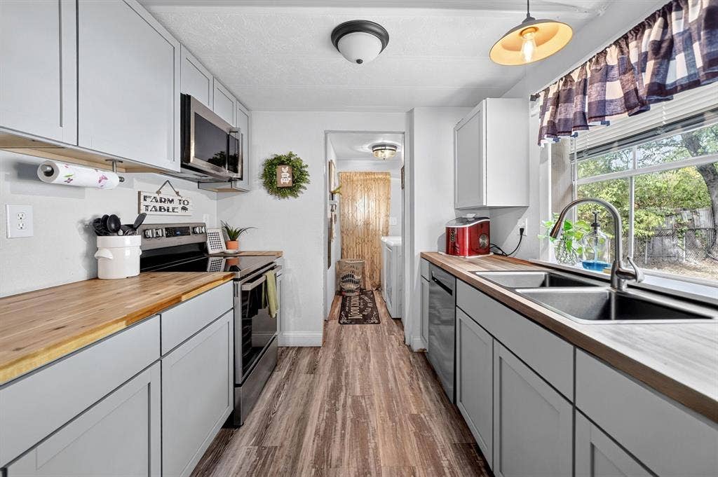 302 Longleaf Street, Gun Barrel City, TX 75156 Light gray cabinetry with wood-finish countertops, stainless steel appliances, and wood-finish flooring