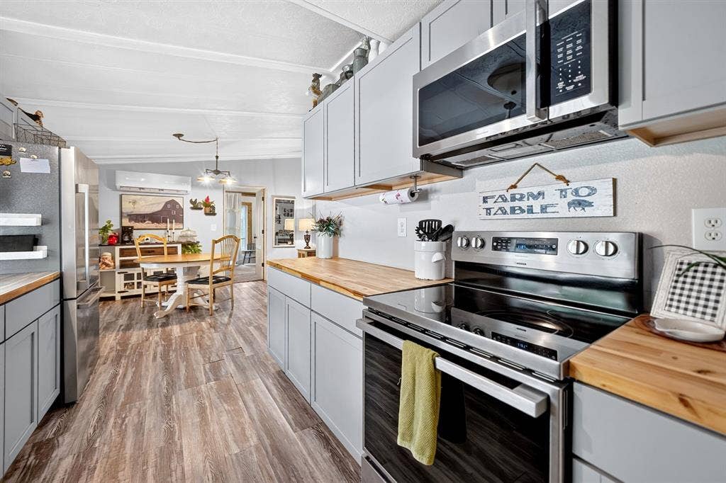 302 Longleaf Street, Gun Barrel City, TX 75156 Kitchen featuring light gray cabinetry, wood-finish countertops, stainless steel appliances, and wood-finish flooring