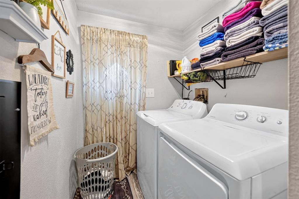 302 Longleaf Street, Gun Barrel City, TX 75156 Laundry area featuring a full-size washer and dryer, built-in shelving, and a window with patterned drapes