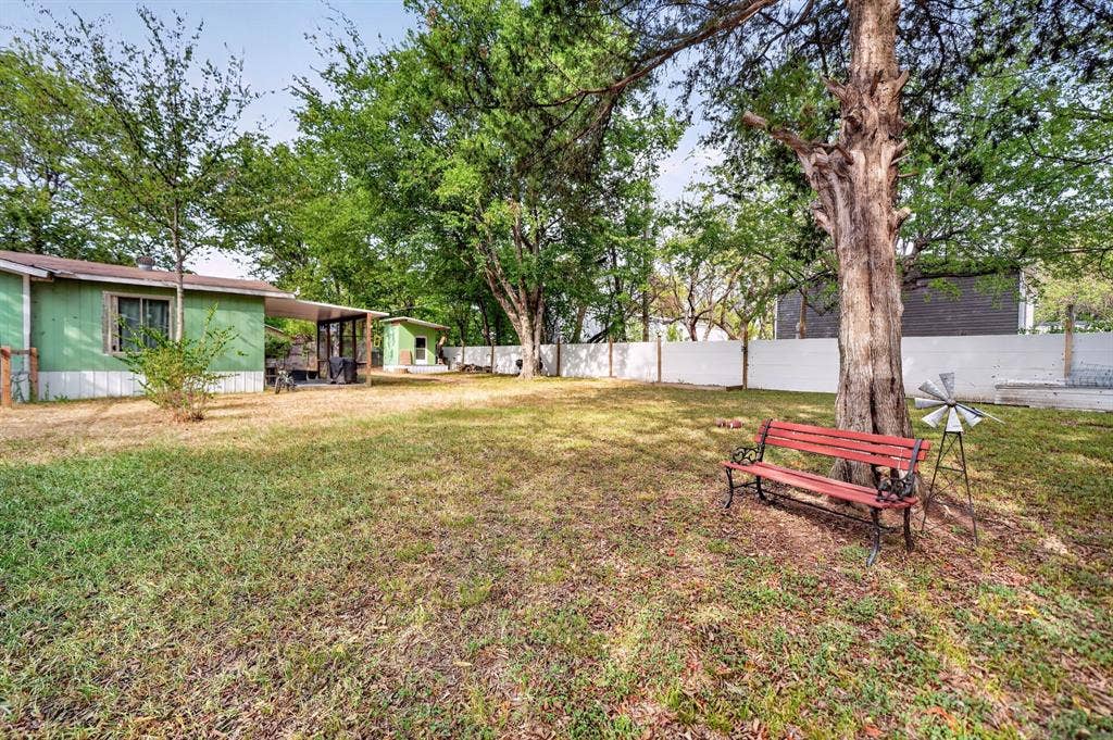 302 Longleaf Street, Gun Barrel City, TX 75156 Expansive yard featuring a manicured lawn, established trees, and a privacy fence