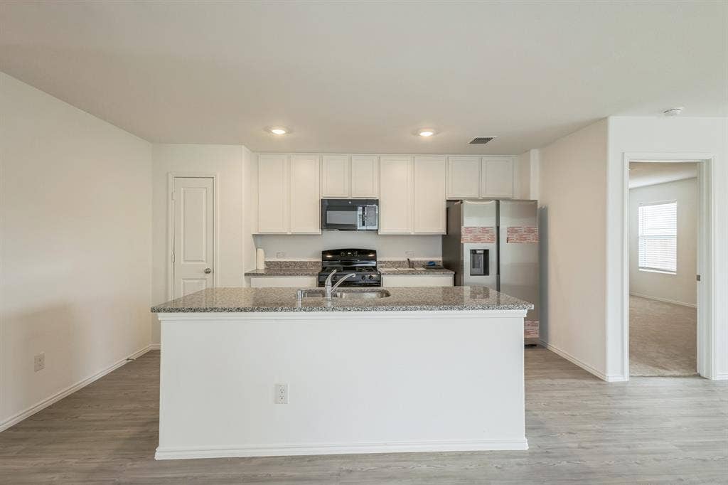 7904 Thornton Drive, McKinney, TX 75071 Kitchen featuring white cabinetry, granite countertops, an undermount sink, and stainless steel appliances