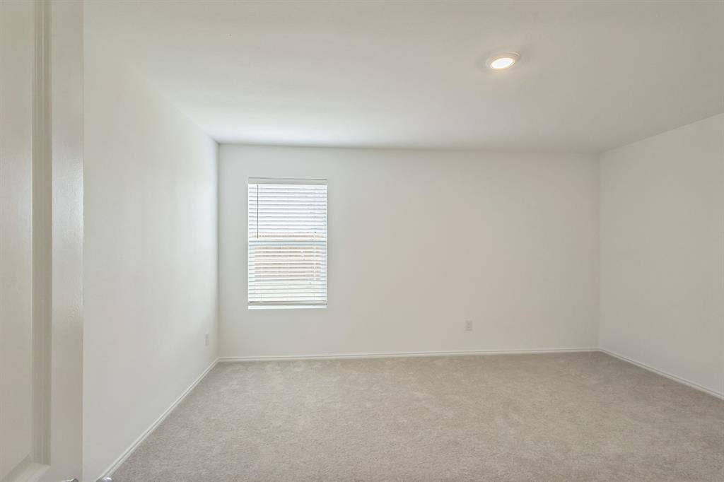 7904 Thornton Drive, McKinney, TX 75071 Neutral-toned carpeting, single window with horizontal blinds, recessed ceiling light, and white painted walls