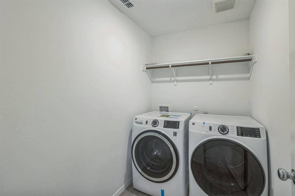 7904 Thornton Drive, McKinney, TX 75071 Dedicated laundry space with a built-in white shelf and hanging rod