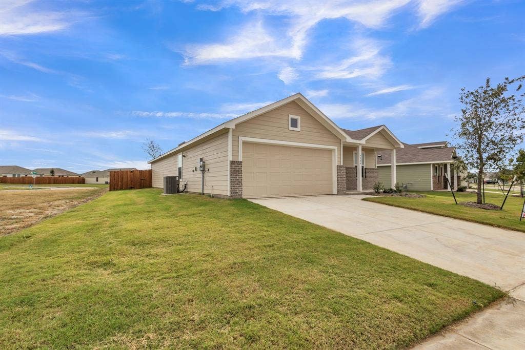 7904 Thornton Drive, McKinney, TX 75071 Single-story property featuring a tan exterior, an attached garage, a concrete driveway, and a manicured lawn