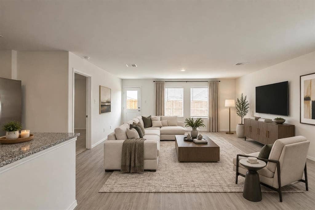 7904 Thornton Drive, McKinney, TX 75071 Open-concept living space featuring wood-finish flooring, recessed lighting, and ample natural light from multiple windows