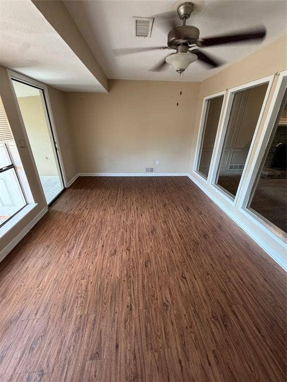 3912 Bandera Drive, Plano, TX 75074 Wood-finish flooring with perimeter baseboards, multiple windows, and a ceiling fan with integrated lighting