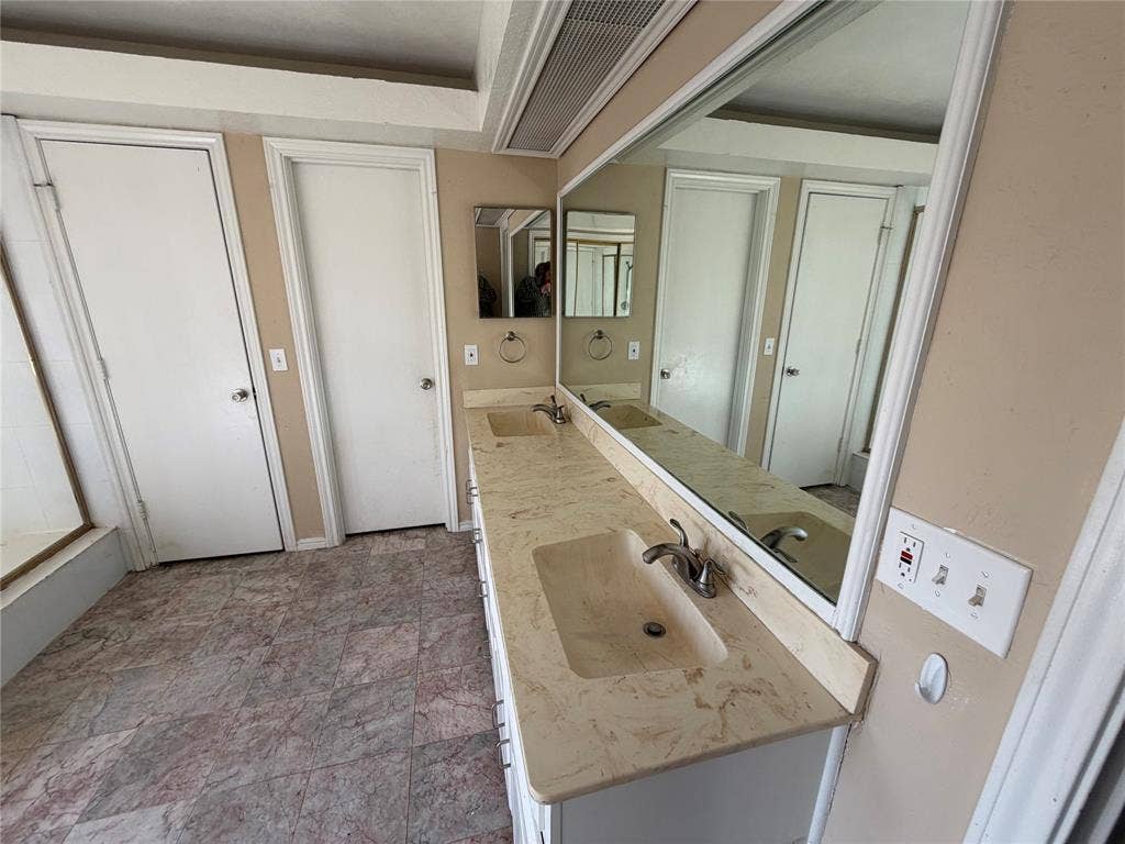 3912 Bandera Drive, Plano, TX 75074 Dual vanity with integrated sinks, expansive mirror, and patterned floor tile