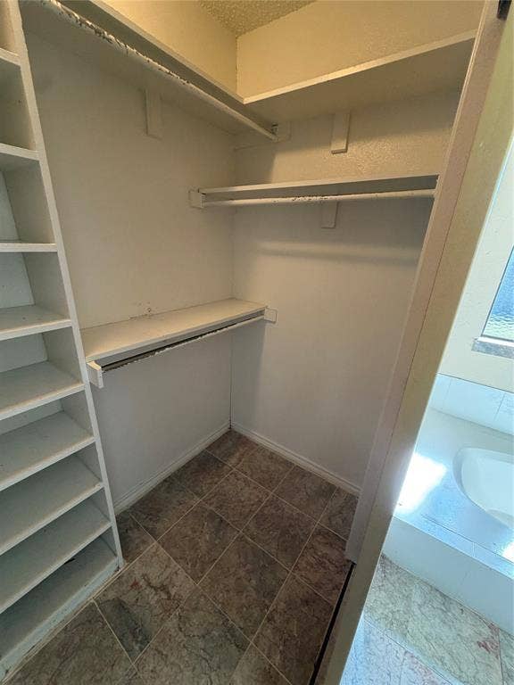 3912 Bandera Drive, Plano, TX 75074 Built-in shelving, multiple hanging rods, and a tiled floor