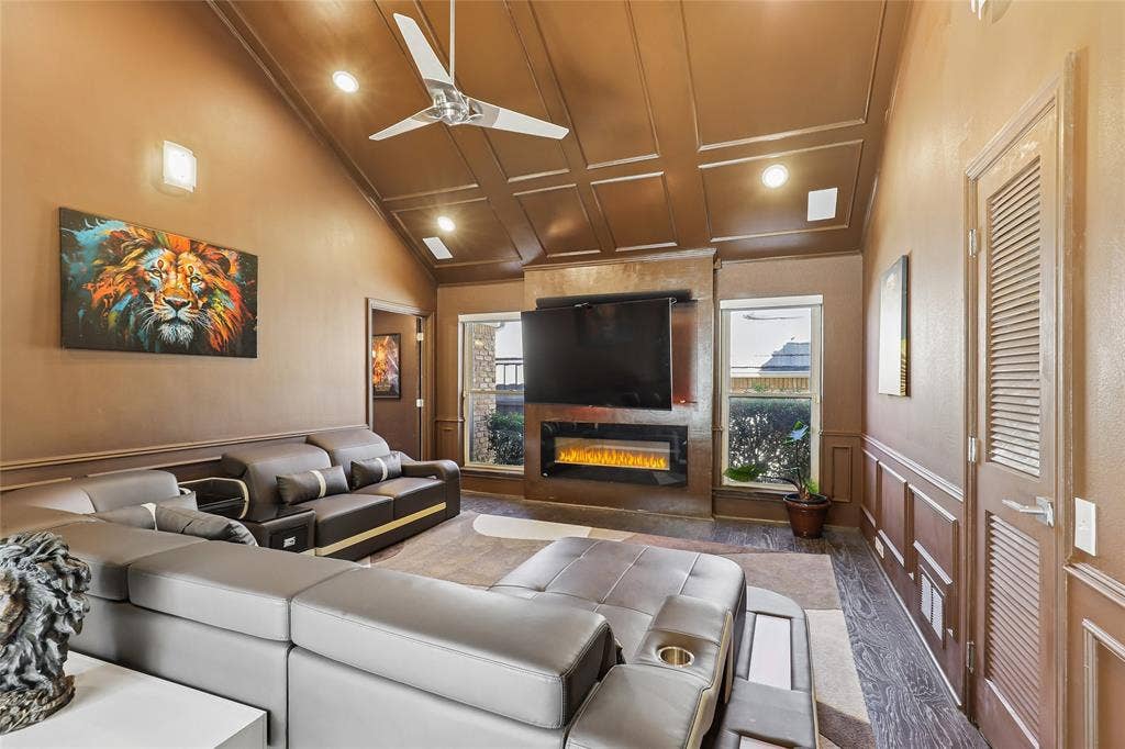 5716 Plumtree Drive, Dallas, TX 75252 Vaulted ceiling with recessed lighting, electric fireplace, and a modern ceiling fan