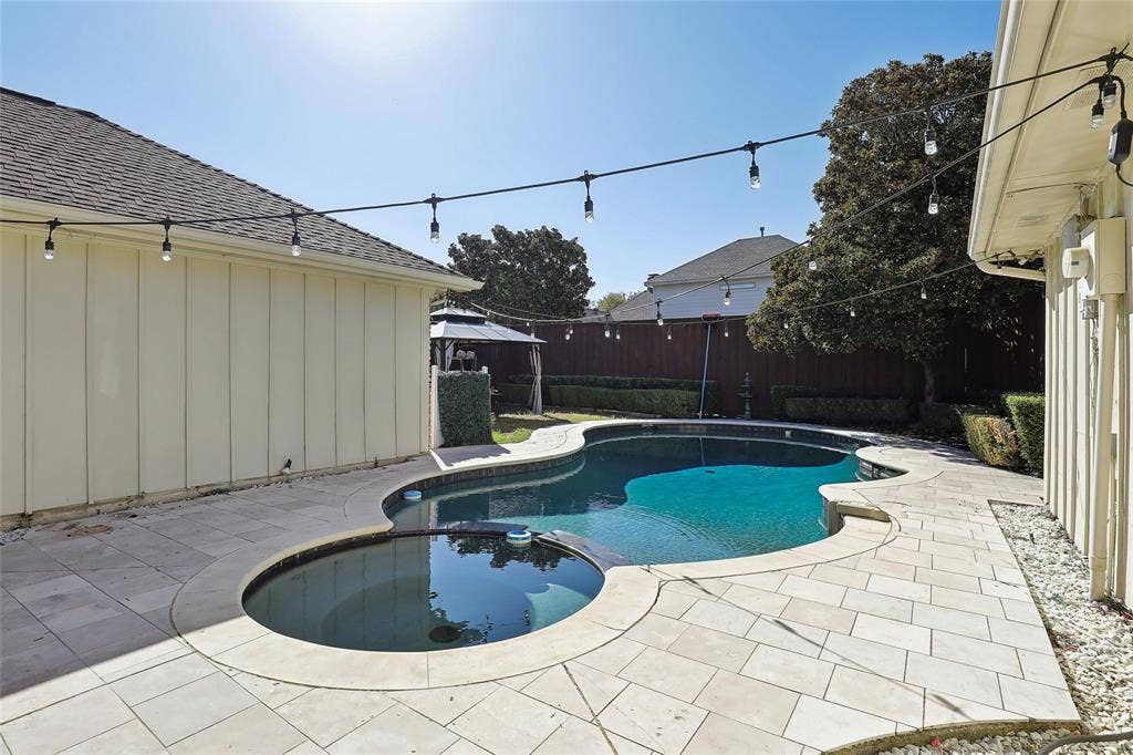 5716 Plumtree Drive, Dallas, TX 75252 Freeform swimming pool with integrated spa and surrounding paver patio