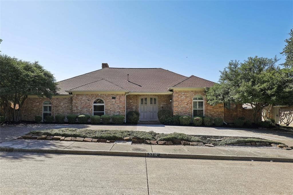 5716 Plumtree Drive, Dallas, TX 75252 Brick exterior with a gabled roof and arched windows