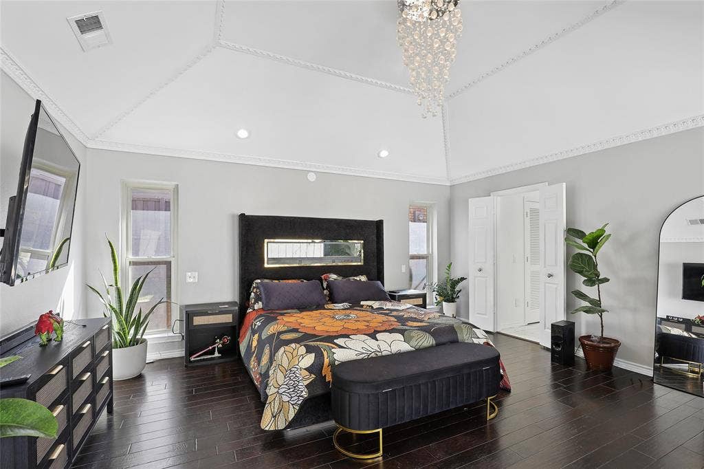 5716 Plumtree Drive, Dallas, TX 75252 Vaulted ceiling with decorative molding, recessed lighting, dark wood-finish flooring, and a crystal chandelier.