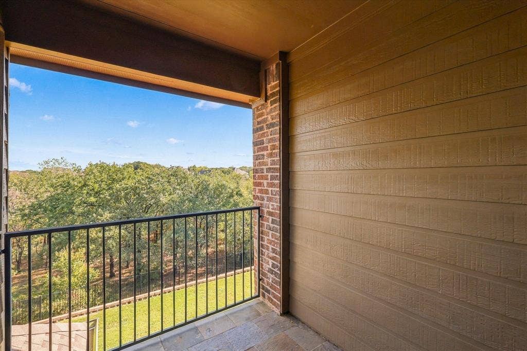 3110 Creek Haven Drive, Highland Village, TX 75077 Covered balcony featuring horizontal lap siding, brick masonry detailing, tile flooring, and a metal railing
