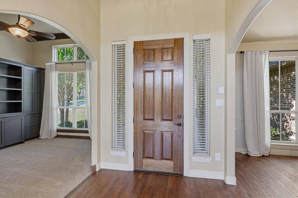 3110 Creek Haven Drive, Highland Village, TX 75077 Entryway featuring a solid wood front door with sidelights, arched architectural detailing, built-in cabinetry, and wood-finish flooring
