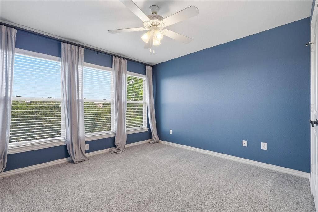 3110 Creek Haven Drive, Highland Village, TX 75077 Neutral-toned wall-to-wall carpeting, three multi-pane windows, and a central ceiling fan with integrated lighting