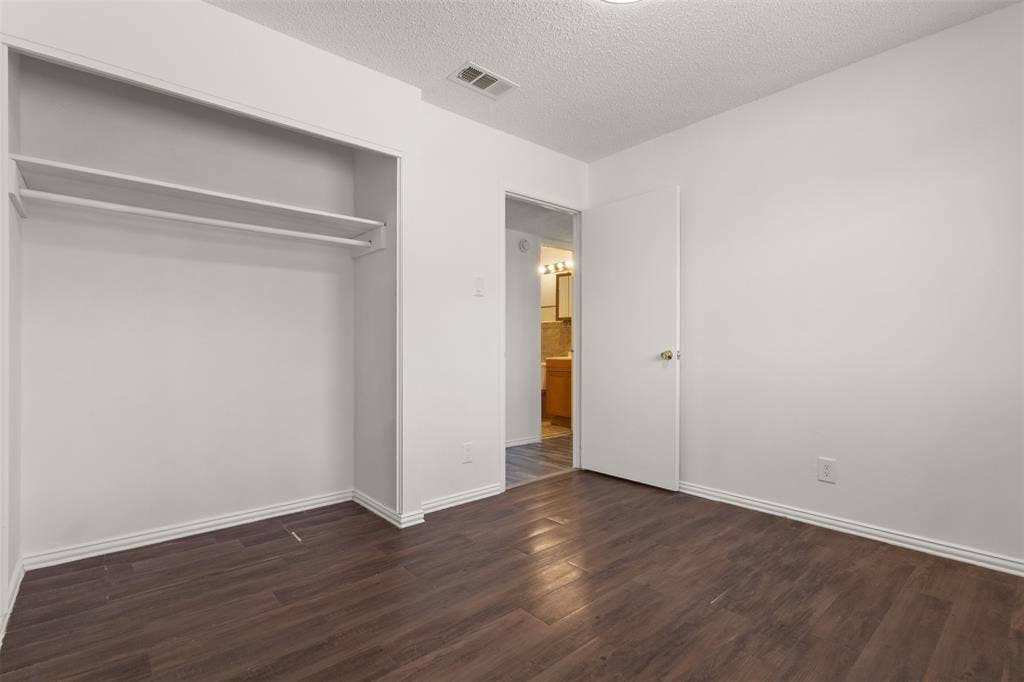 2563 Wood Valley Drive, Dallas, TX 75211 Wood-finish flooring, built-in closet shelving, and a bright white interior