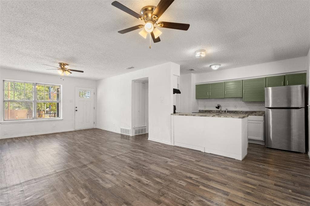 2563 Wood Valley Drive, Dallas, TX 75211 Open-concept living space featuring wood-finish flooring, white walls, and dual ceiling fans