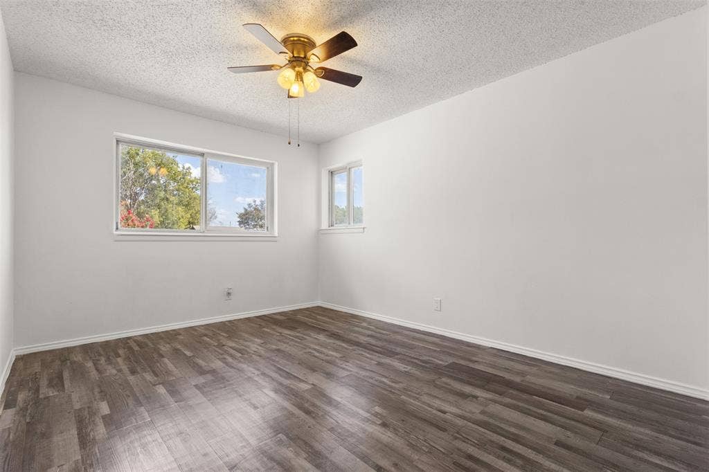 2563 Wood Valley Drive, Dallas, TX 75211 Wood-finish flooring, white painted walls, ceiling fan with integrated lighting, and multiple windows