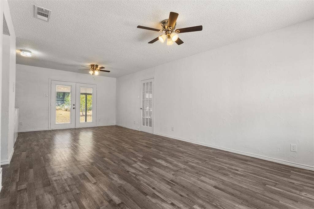 2563 Wood Valley Drive, Dallas, TX 75211 Spacious interior featuring wood-finish flooring, white walls, and dual ceiling fans