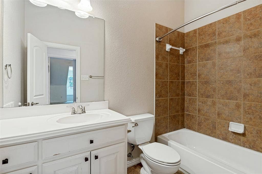 806 Cobblestone Court, Cedar Hill, TX 75104 White vanity with integrated sink, brushed nickel faucet, large mirror, and overhead vanity lighting
