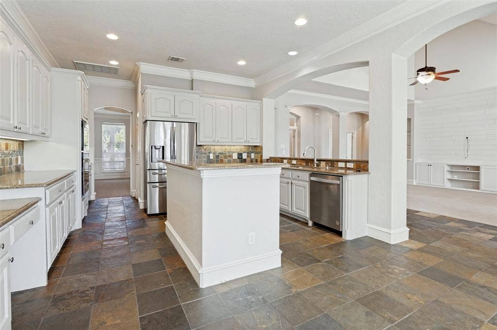 806 Cobblestone Court, Cedar Hill, TX 75104 White cabinetry, stainless steel appliances, stone tile flooring, granite countertops, and recessed lighting