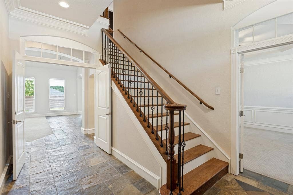 806 Cobblestone Court, Cedar Hill, TX 75104 Slate tile flooring, hardwood staircase with wrought iron balusters, arched entryway with transom window, and recessed lighting
