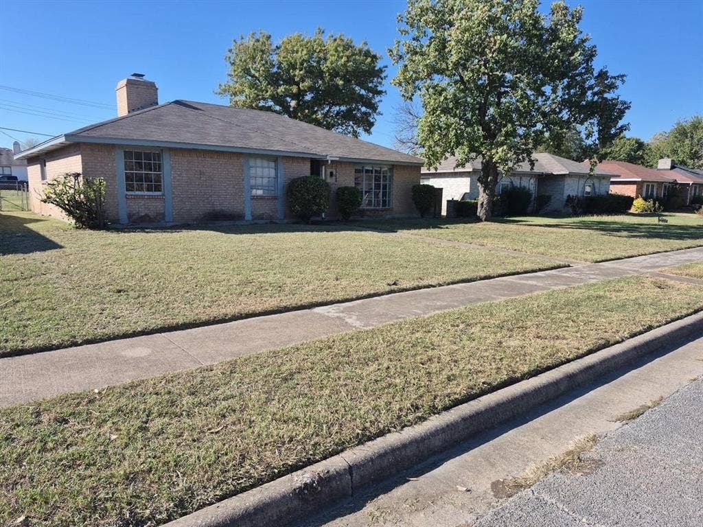 2705 Tanglewood Drive, Lancaster, TX 75134 Brick exterior with a prominent chimney, front lawn, and mature trees