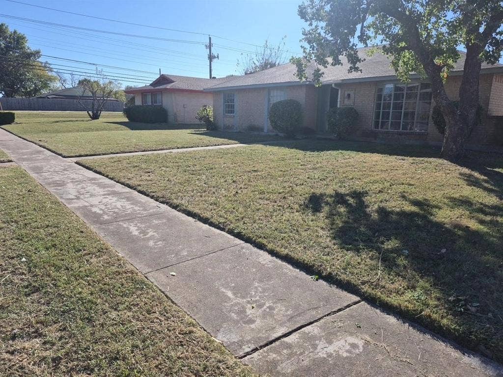 2705 Tanglewood Drive, Lancaster, TX 75134 Brick exterior with a mature tree, front lawn, and concrete sidewalk