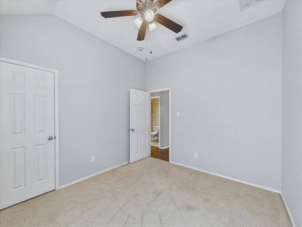 Carpeted room with a ceiling fan, light gray walls, and white trim