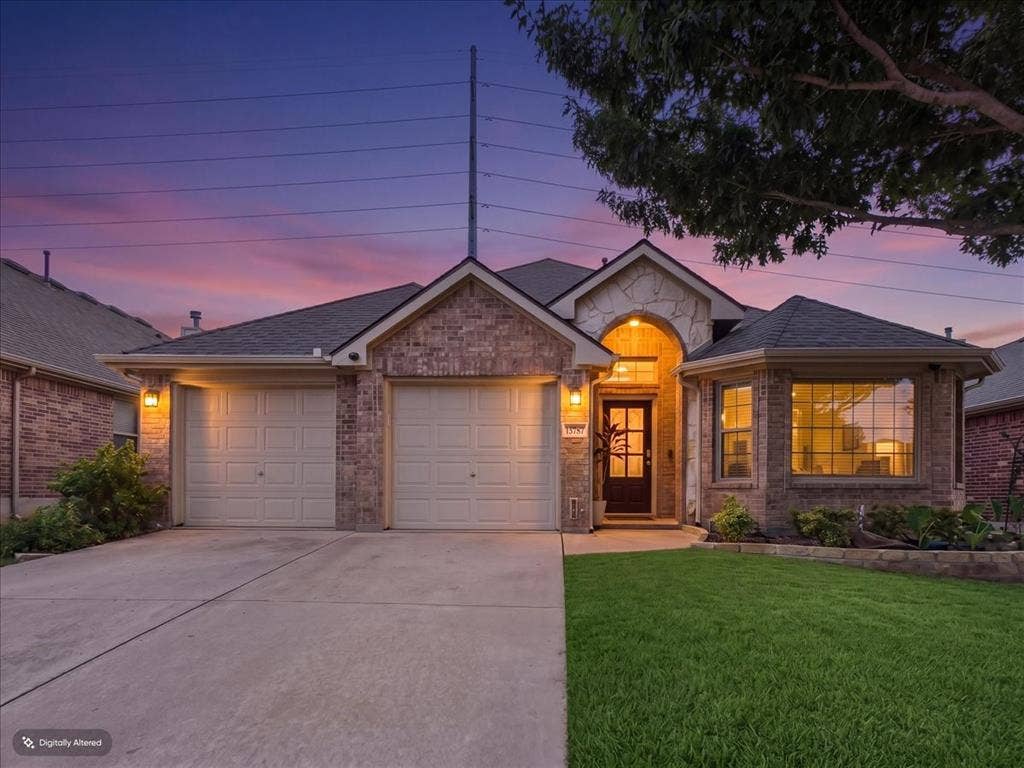 Brick and stone facade, two-car garage, concrete driveway, manicured lawn, and mature trees