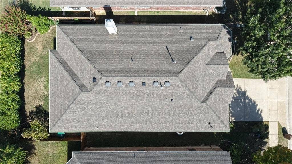 Asphalt shingle roofing with multiple roof vents and a chimney