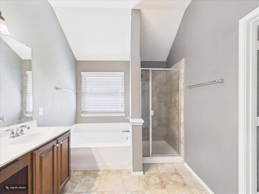 Walk-in shower with clear glass enclosure, a built-in tub, and a vanity with a white countertop and wood-finish cabinetry