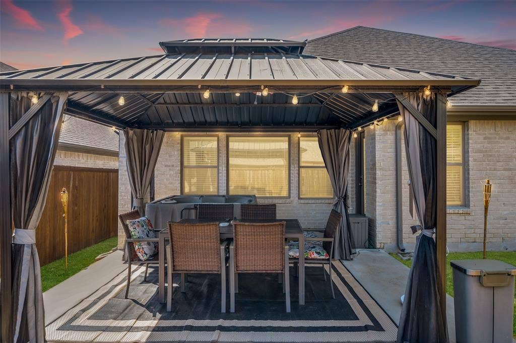 632 Cherry Hills Road, Red Oak, TX 75154 Patio area featuring a dark metal gazebo with string lighting, privacy curtains, and concrete hardscaping