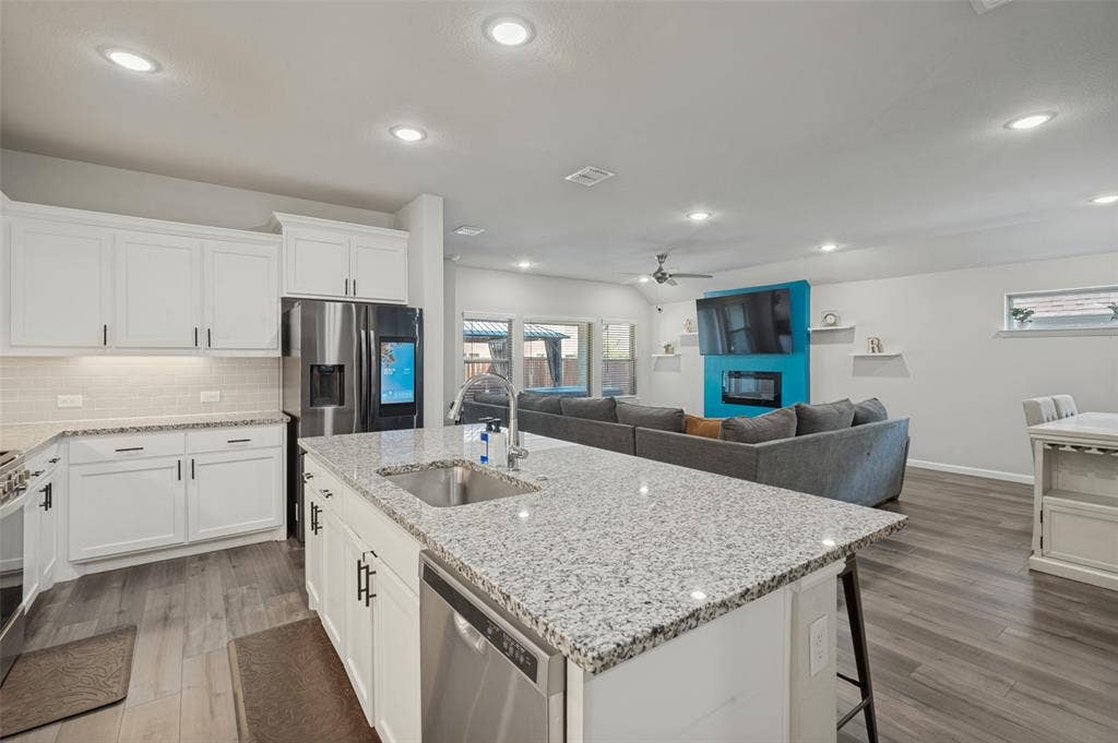 632 Cherry Hills Road, Red Oak, TX 75154 White cabinetry, stainless steel appliances, granite countertops, wood-finish flooring, and recessed lighting