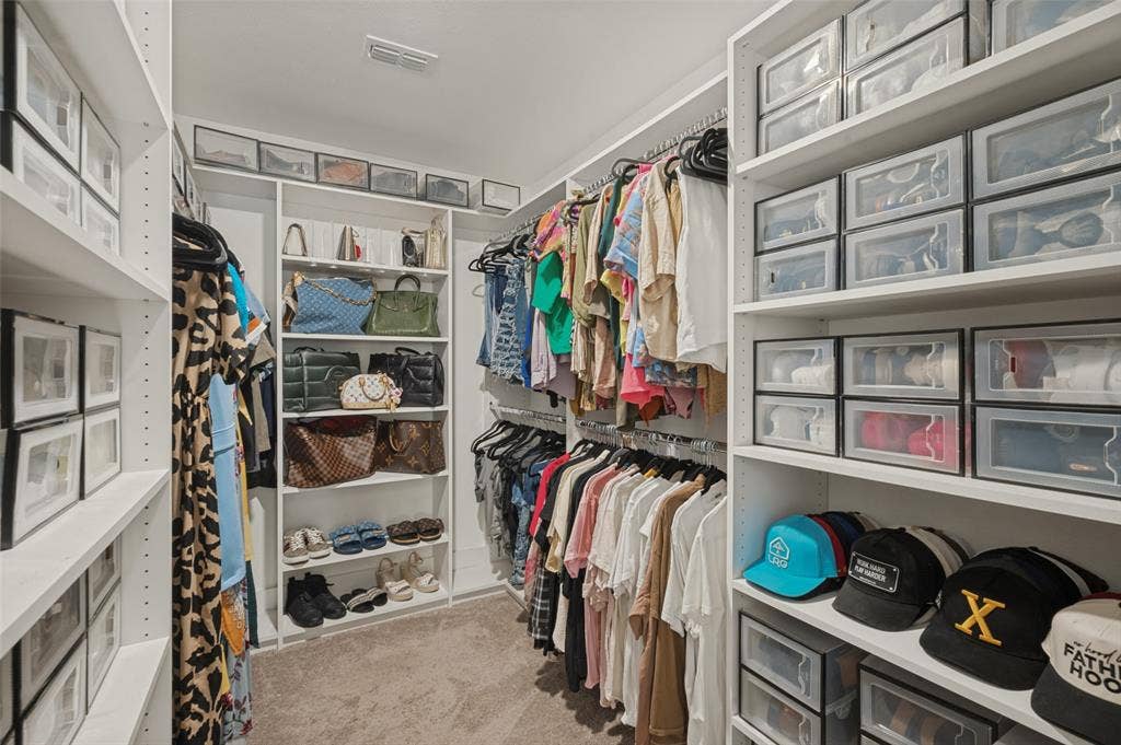 632 Cherry Hills Road, Red Oak, TX 75154 Walk-in closet featuring extensive built-in shelving, multiple hanging rods, and recessed lighting