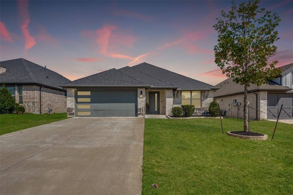 632 Cherry Hills Road, Red Oak, TX 75154 Single-story residence featuring a dark gray shingle roof and a two-car garage with horizontal paneling