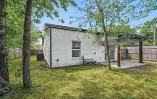 White-painted brick exterior featuring a covered patio, wooden support columns, and perimeter wood fencing