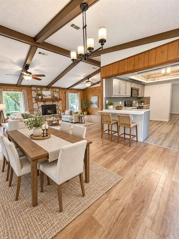 102 Rye Place, Gun Barrel City, TX 75156 Vaulted ceiling with exposed wood beams, wood-finish flooring, stone-clad fireplace, and kitchen with breakfast bar