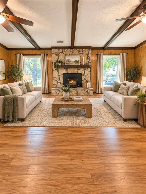 102 Rye Place, Gun Barrel City, TX 75156 Wood-finish flooring, stone fireplace with hearth, wood paneled walls, exposed ceiling beams, and dual ceiling fans