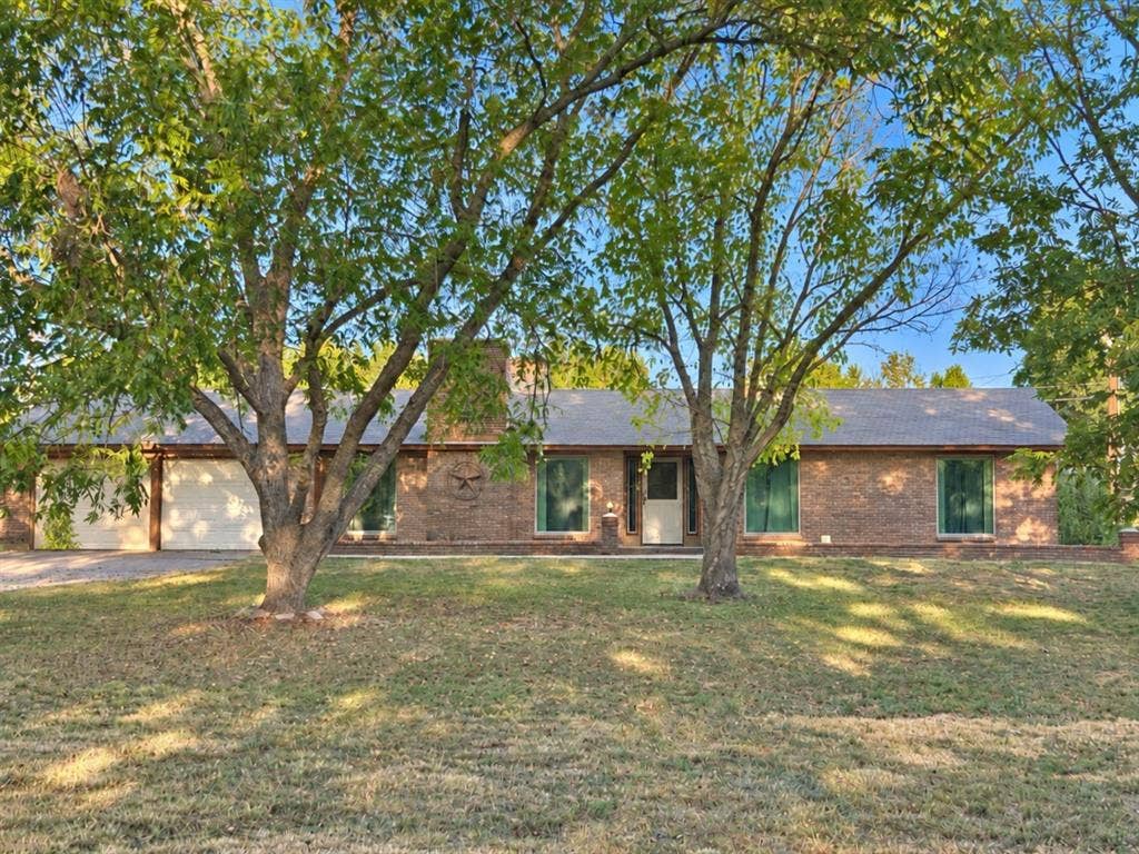 102 Rye Place, Gun Barrel City, TX 75156 Brick exterior with a prominent chimney, two garage doors, and a covered entry