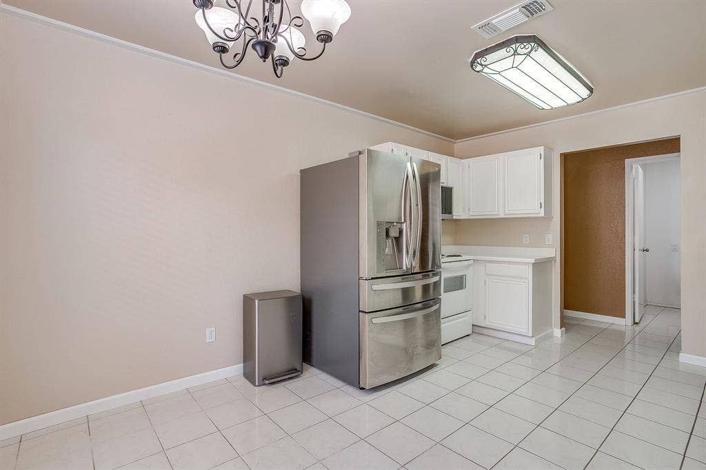 Kitchen featuring white cabinetry, ceramic tile flooring, a stainless steel multi-door refrigerator, and a decorative chandelier