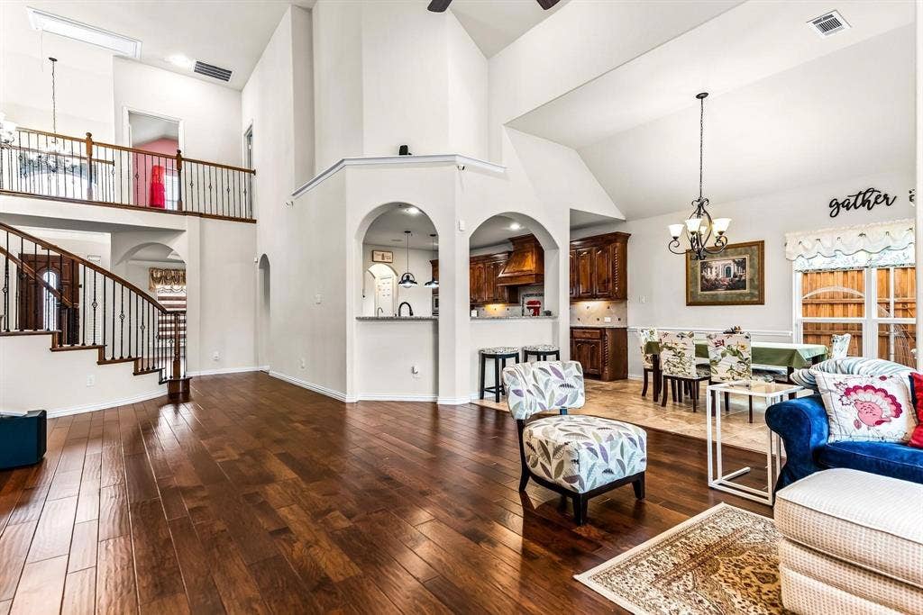 12467 Fallcreek Drive, Frisco, TX 75035 Vaulted ceilings, wood-finish flooring, staircase with wrought iron balusters, arched openings, and recessed lighting