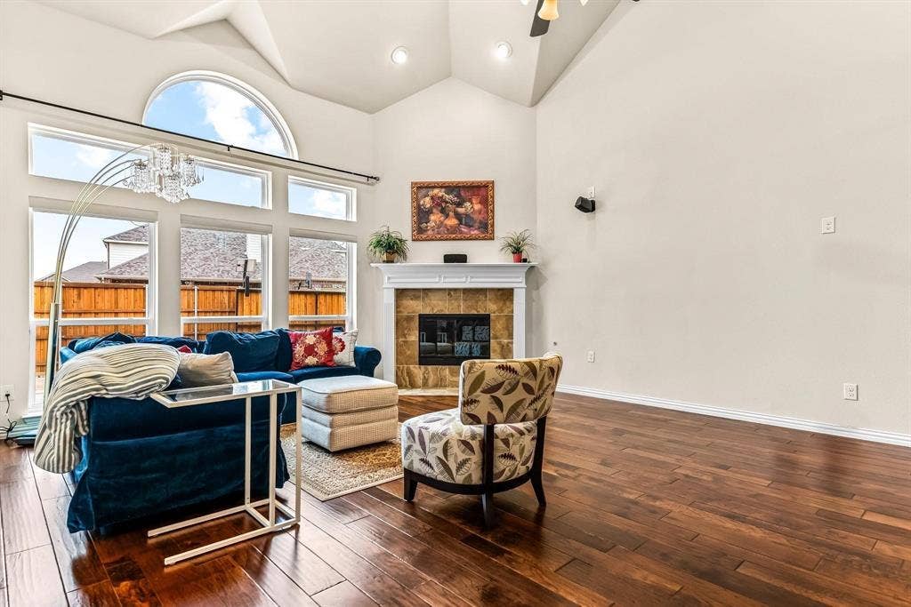 12467 Fallcreek Drive, Frisco, TX 75035 Vaulted ceiling, arched transom window, wood-finish flooring, fireplace with tile surround, and mantel