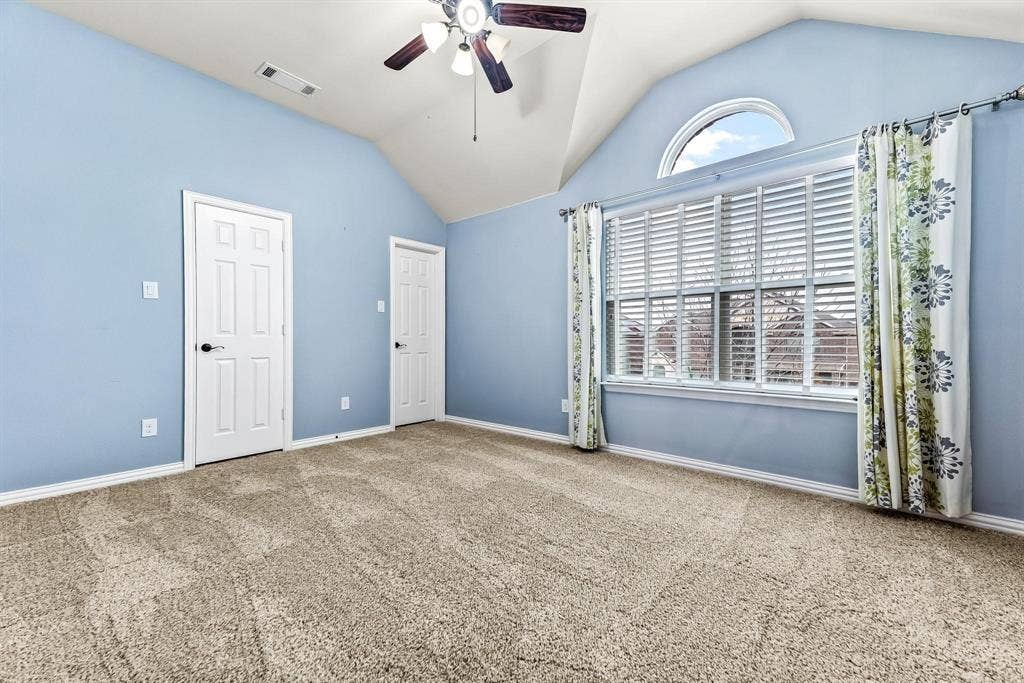 12467 Fallcreek Drive, Frisco, TX 75035 Vaulted ceiling, ceiling fan with light fixture, arched window, six-panel interior doors, and carpeted flooring