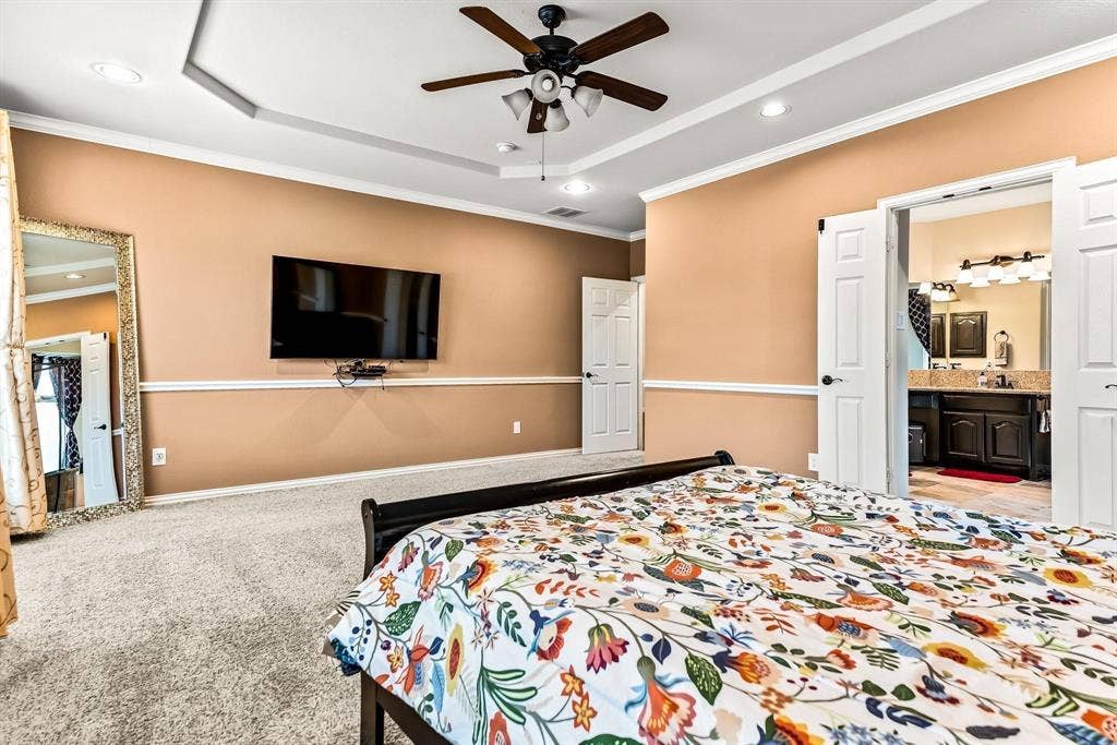 12467 Fallcreek Drive, Frisco, TX 75035 Recessed ceiling, ceiling fan with integrated lighting, wall-mounted television, double doors, and a bathroom vanity with dual sinks