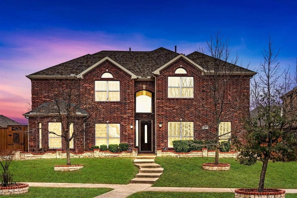 12467 Fallcreek Drive, Frisco, TX 75035 Red brick exterior featuring a multi-gabled roofline, arched entry, and prominent front-facing windows