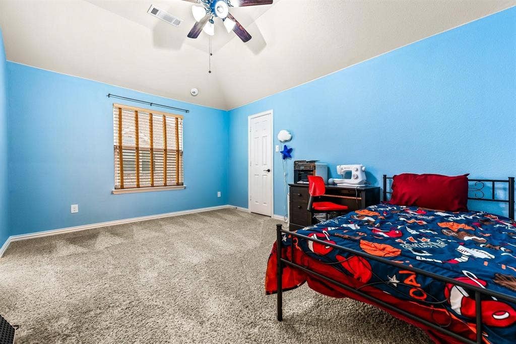 12467 Fallcreek Drive, Frisco, TX 75035 Vaulted ceiling with a ceiling fan, window with horizontal blinds, light-toned carpet flooring, and a white door